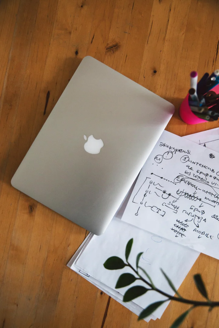 A laptop and notes on a wooden desk